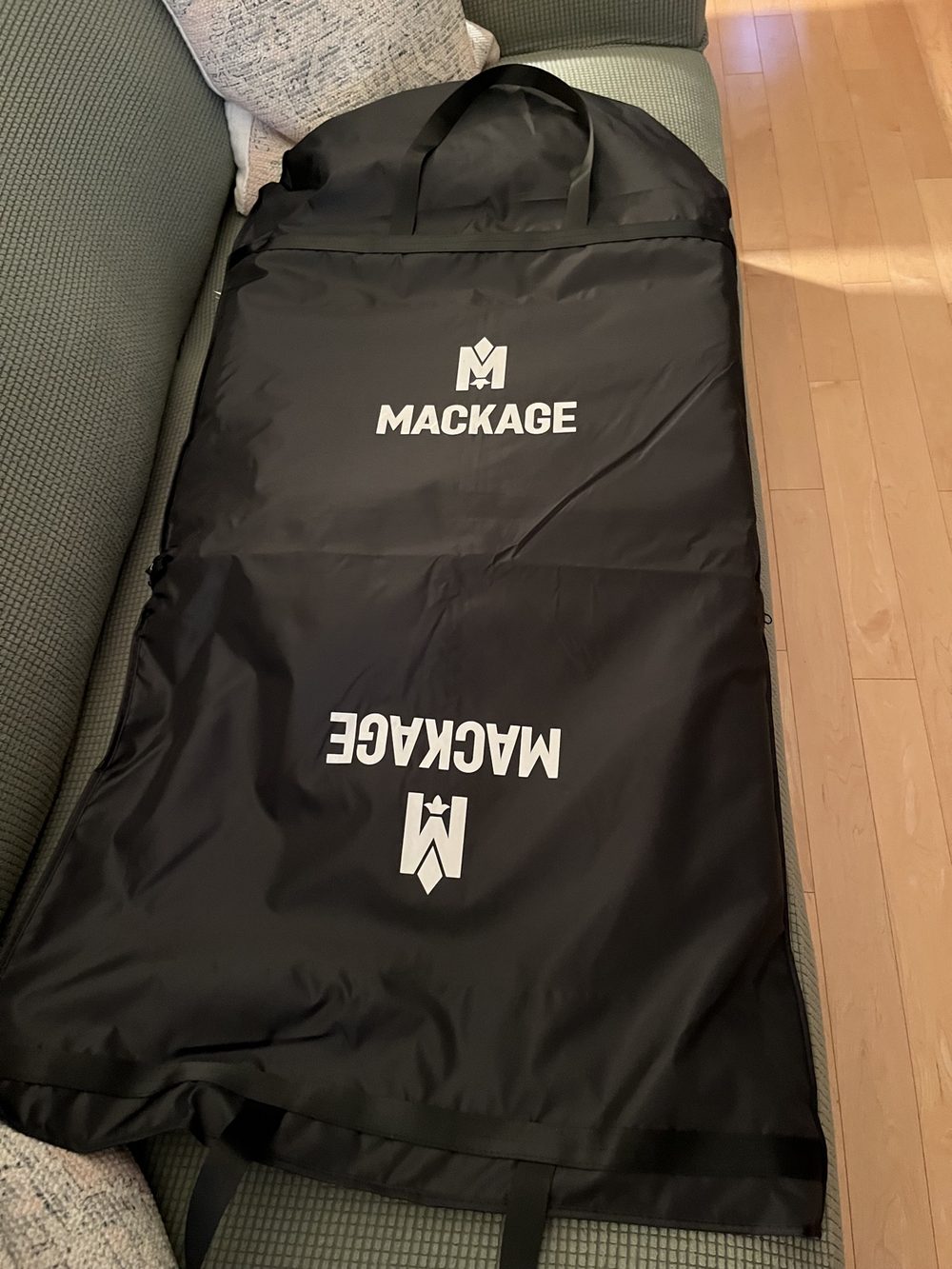 The Mackage garment bag the Moritz-X ships and stores in, laid out on a couch
